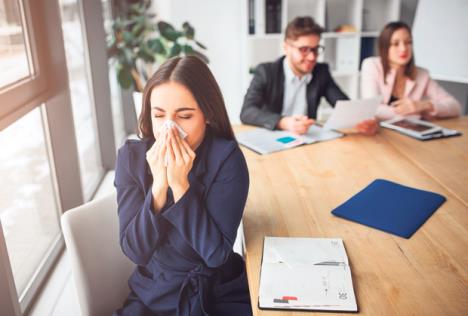 stockphotosickyoungwomansitsaparatelyattableinmeetingroomandsneezingsheholdwhitenapkinher1304942413.jpg