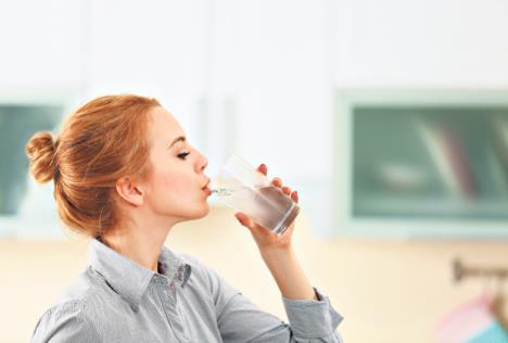 stockphotoyoungwomaninthekitchendrinkingwater427251640.jpg