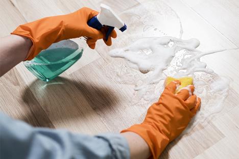 Ruke sa naradžastim rukavicama ribaju pod