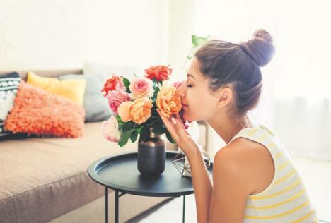 stockphotowomansmellingfreshrosesinvaseontablehousewifetakingcareofcozinessinapartment1429373165.jpg