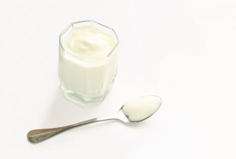 stockphotoglasswithnaturalyoghurtandspoononwhitetable585972503.jpg