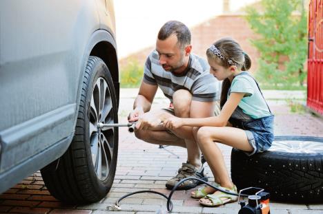 stockphotocutelittlegirlhelpsherfathertochangewheelontheirfamilycaronwarmdayintheyard209079157-08-05-2020.jpg