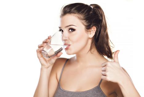 stockphotoyoungbeautifulwomandrinkswaterfromaglassandshowingthumbsup176286527.jpg