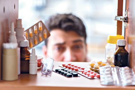 stockphotosickillmanlookingformedicinesatfarmacyshelf758453590.jpg