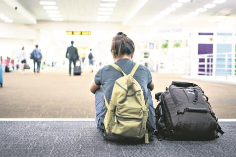 0808stockphotoyoungwomanwithbackpackinairportnearflighttimetabledelayedairplaneconcept1165843993.jpg