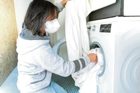 0605-stockphotocoronaviruswomandoingthelaundryathomewithfacemaskusingwashingmachinecoronavirus1687305484.jpg