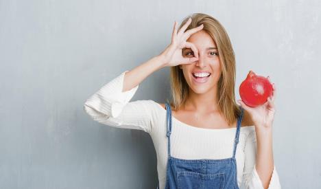 stockphotobeautifulyoungwomanovergrungegreywallholdingpomegranatewithhappyfacesmilingdoingok1156163446.jpg