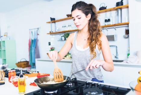 stockphotoportraitofyoungwomanfryingonionintothepaninthekitchen532528291.jpg