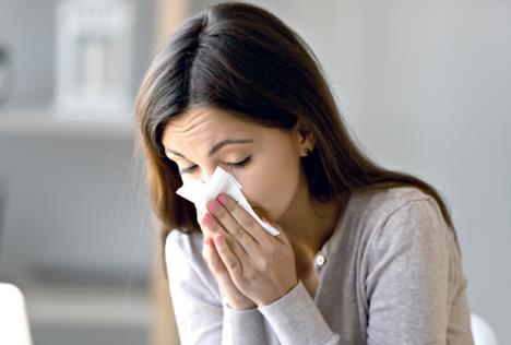 stockphotosickyoungwomansittingindoorsholdingtissuehandkerchiefblowingrunningnosefeelsunwell1354368317.jpg