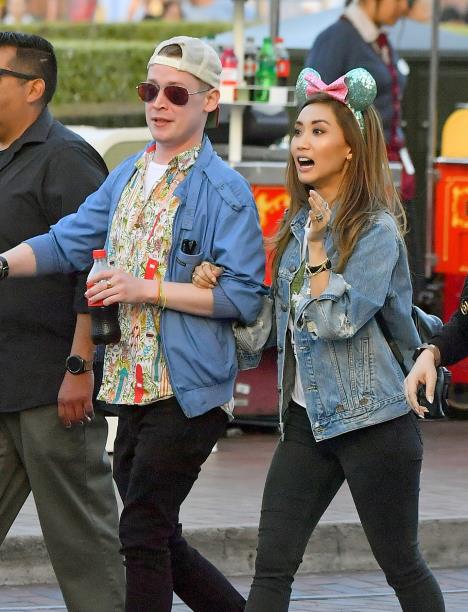 Mekoli Kalkin i Brenda Song u voznom parku šetaju ulicom