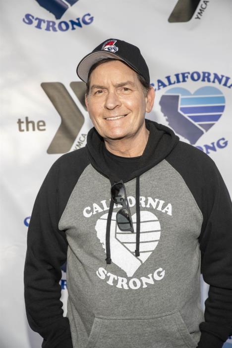 Čarli Šin u duksu sa kačketom na glavi