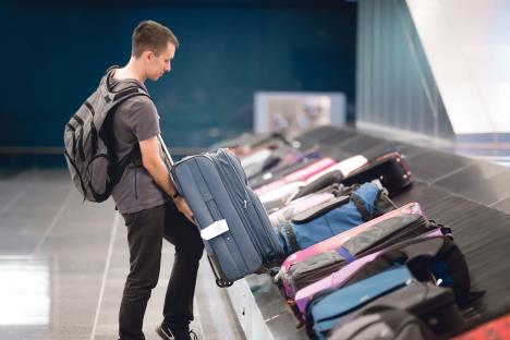 stockphotosideviewportraitofyounghandsomemanpassengerinswithcarryonbackpackcollectinghis521627293.jpg