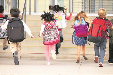 stockphotoelementaryschoolkidsrunningintoschoolbackview388630444.jpg