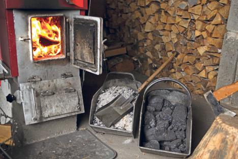 stockphotofirewoodisburninginthestoveheatingthehousewithlogsandcoalinlargemetalbaskets1552761383.jpg