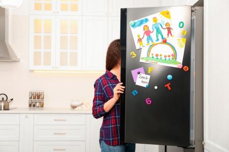 urednije-je-bez-crteza-i-magneta--stockphotowomanopeningrefrigeratordoorwithchildsdrawingsnotesandmagnetsinkitchenspacefortext1660187650.jpg