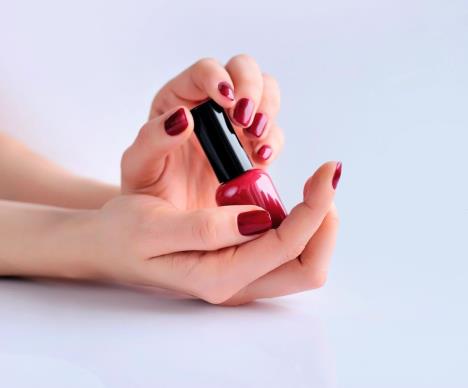 stockphotohandsofawomanwithdarkredmanicureandnailpolishbottle569020645.jpg