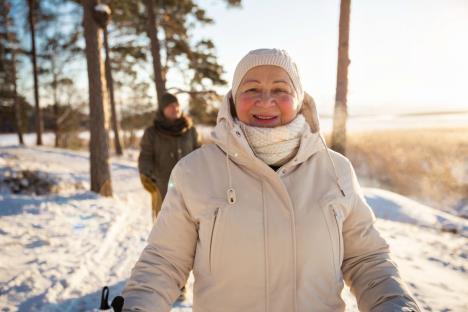 stockphotowintersportinfinlandnordicwalkingseniorwomanandmanhikingincoldforestactivepeople554386915.jpg