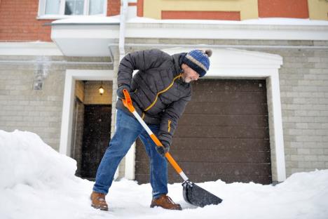 stockphotoamaturemancleanpathnearhousefromsnowduringstrongblizzardpersonshovelingsnowoutof1916740610.jpg