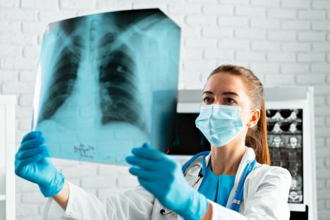 stockphotofemaledoctorinmedicalmaskexaminesxrayscanoflungs1914544000.jpg