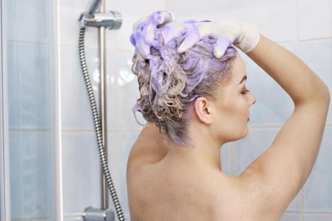 stockphotowomanapplyingcoloringshampooonherhairfemalehavingpurplewashingproducttoningblonde1843958596.jpg