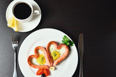 stockphotoscrambledeggsintheformofheartonawhiteplatewithsausagestomatoesgreensandcoffee1027687471.jpg