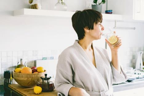 limunov-sok-stockphotowomaninthebathrobedrinkingwaterwithlemoninhermodernwhitekitchenmorninghealthydiet2080711171.jpg