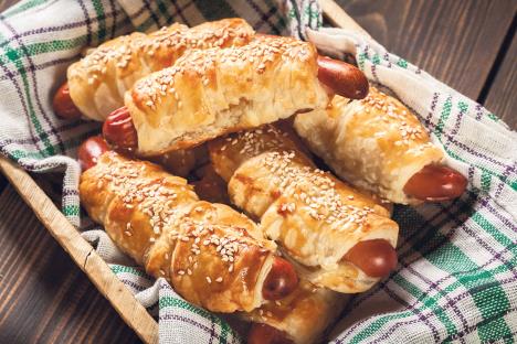 stockphotorolledhotdogsausagesbakedinpuffpastryinawickerbasket1063848761.jpg