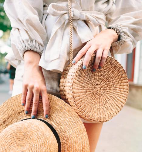 stockphotostylishwomansoutfitnaturestylishtopstrawbagwhitedresswomanhandswithfashionable1124907914.jpg