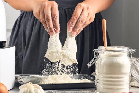 stockphotoselectedfocusfemalehomechefmakinghomemadecrispyfriedchickencoatingchickendrumsticks1854224173.jpg