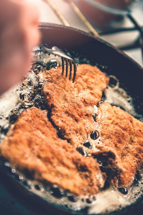 stockphotowomanfryingchickenonfryingpan551453209.jpg