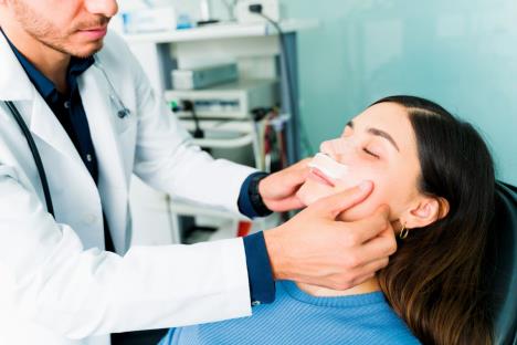 ne-plaite-se-intervencije--stockphotohispanicotolaryngologistputtingabandageinthenoseofafemalepatientafterasurgeryto2001282275.jpg