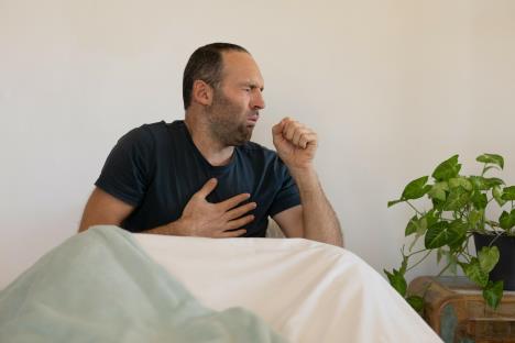 Muškarac kašlje i drži se za grudi