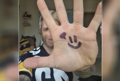 Džono Lankaster pruža šaku ka kameri na kojoj je nacrtan smajli