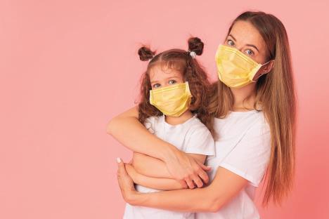 glavna-stockphotocaringforlovedonesyoungmotherhugslittledaughterinprotectivemedicalmasksduringcovid1746930218.jpg