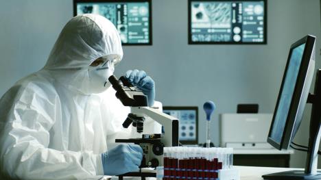 stockphotoscientistinprotectionsuitandmasksworkinginresearchlabusinglaboratoryequipment1713142675.jpg