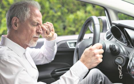 stockphototiredseniormanrubbinghiseyesbehindsteeringwheelofcar1731109489.jpg