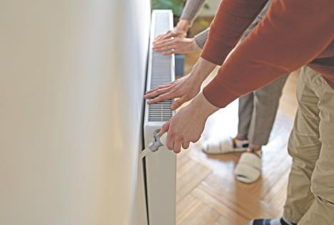 0802-stockphotofamilycouplebalancingthermostaticradiatorcroppedphotomanhomeownerturningcentralheating2259616783.jpg