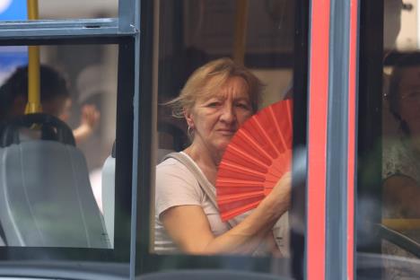 Žena se hladi lepezom u prevozu