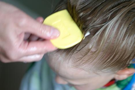 Majka drži češalj u kosi devojčici