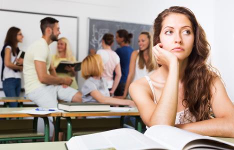 0607-stockphotodejectedlonelystudentwithsadexpressionsitsatherdeskintheclassroom342018293.jpg