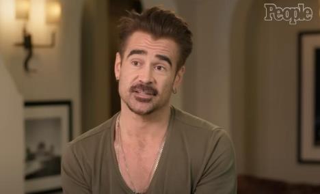 Glumac Kolin Farel u maslinasto zelenoj majici sa dubokim okovratnikom