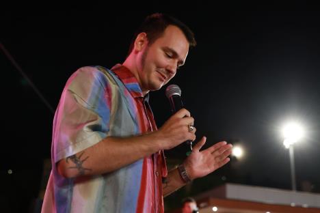 Aleksa Balašević u šarenoj prugastoj košulji drži mikrofon