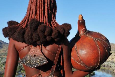 Žena naroda Himba u Namibiji sa tradicionalnim pletenicama i kožom premazanom crvenom pastom otjize