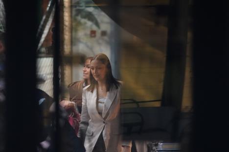 Aleksandra Prijović u bež sakou i beloj majici, nasmejana hoda u društvu žene