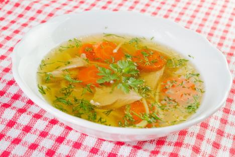 Tanjir domaće supe na kariranom stoljnjaku