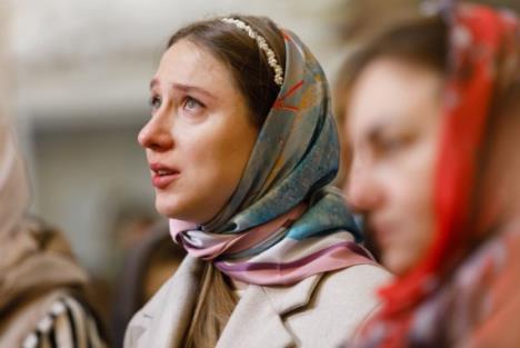 Devojka sa maramom na glavi se moli u crkvi