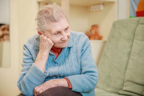 Baka u plavom džemperu sedi na trosedu u dnevnoj sobi