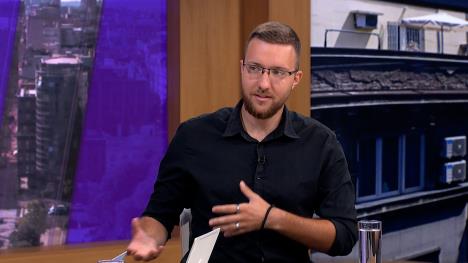 Mlad muškarac u crnoj košulji u televizijskom studiju