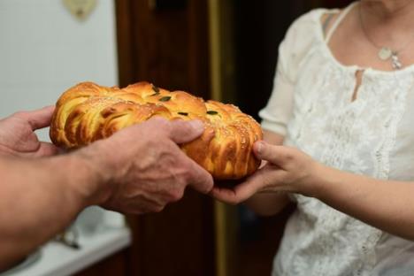 Muškarac i žena okreću slavski kolač