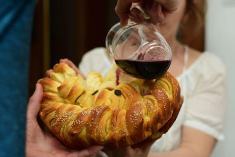 Muškarac vinom preliva slavski kolač